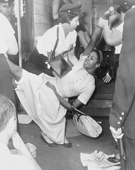 An African American woman is carried to a police patrol wagon during demonstrations in Brooklyn.